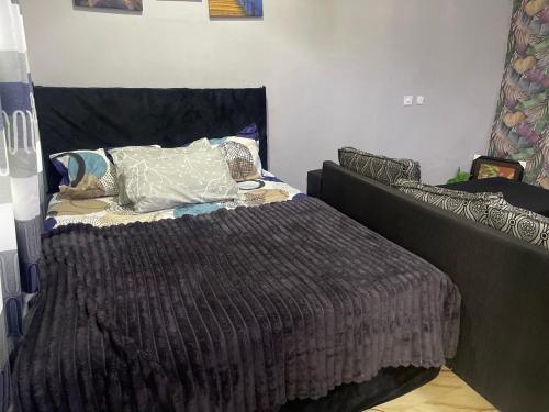 a bed with a brown comforter in a bedroom at Skl apartment in Adentan