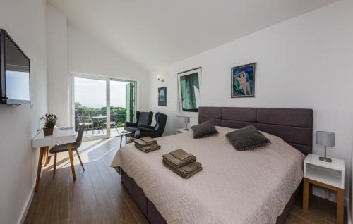 a bedroom with a bed and a table and chairs at Villa Lun T - Island Pag by Villas Guide in Lun