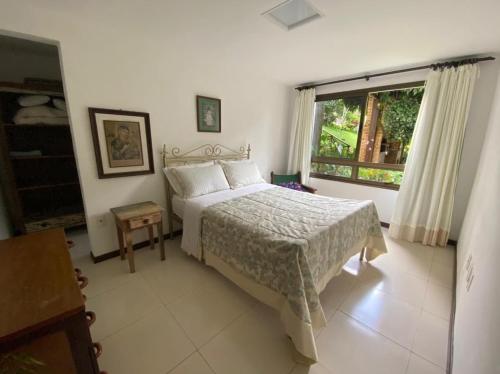 un dormitorio con una cama y una ventana en Guaramiranga MonteFlor, en Guaramiranga
