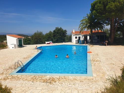 un groupe de personnes nageant dans une piscine dans l'établissement Belle maison Lila Jade avec superbe vue à 180 degrés piscine partagée, à Laroque-des-Albères