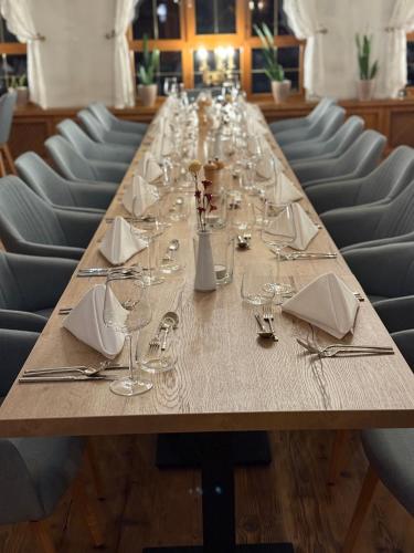 a long table with wine glasses and napkins at Das Traditionshotel Schwarzer Adler in Tannheim