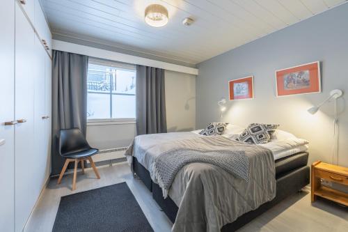 a bedroom with a bed and a chair and a window at Kuukkeli Apartments in Saariselka