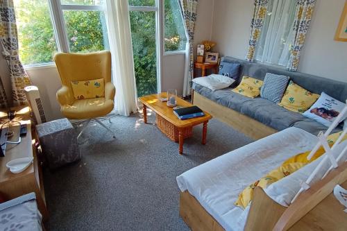 una sala de estar con un sofá y una silla en Comfortable family caravan in Weymouth, en Weymouth