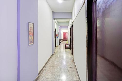 Un pasillo con paredes blancas y suelo de baldosas. en Hotel O Raj Mahal, en Kānpur