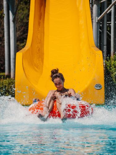 a young girl riding on a raft in a water slide at Onyx Luxury in Sárvár