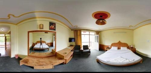 a large room with two beds and a mirror at Pachamama Hotels- Vashisht in Manāli