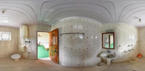 a bathroom with a sink and a mirror at Pachamama Hotels- Vashisht in Manāli