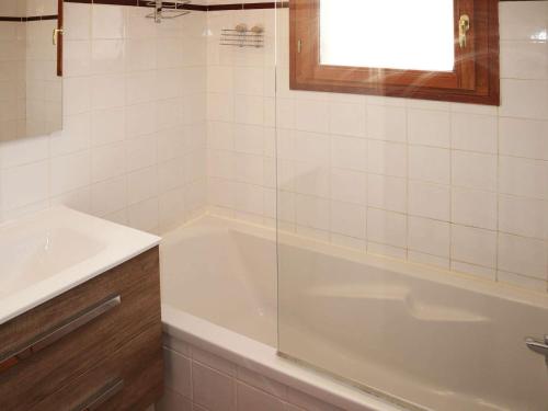 une salle de bain avec une baignoire blanche et un lavabo dans l'établissement Chalet de standing avec piscine, sauna et hammam - 6/7 pers, au pied des pistes Les Orres 1800 - FR-1-322-434, aux Orres