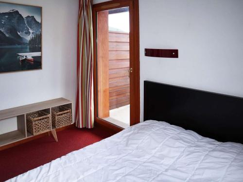 une chambre avec un lit blanc et une fenêtre dans l'établissement Chalet de standing avec piscine, sauna et hammam - 6/7 pers, au pied des pistes Les Orres 1800 - FR-1-322-434, aux Orres
