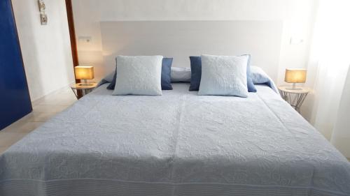 エス・カロにあるAstbury Apartments Ses Platgetesのベッドルーム(青い枕の大型ベッド1台付)