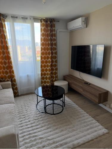 un salon avec un canapé et une télévision dans l'établissement T3 refait à neuf calme et fonctionnel, à La Celle-sous-Gouzon