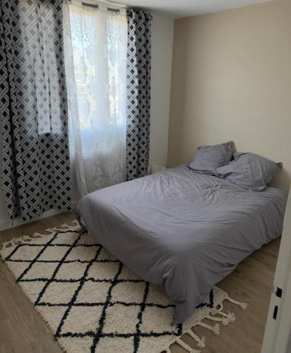 - un lit dans une chambre dotée d'une fenêtre et d'un tapis dans l'établissement T3 refait à neuf calme et fonctionnel, à La Celle-sous-Gouzon