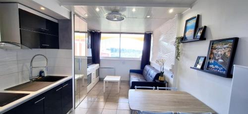- une cuisine avec une table et un canapé dans une chambre dans l'établissement Studio Cabine Vue Port avec parking privé, au Cap d'Agde