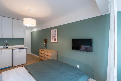 Cette chambre comprend un lit et une cuisine équipée d'une télévision. dans l'établissement M110 Marquer Joli Studio proche du centre et de la gare, à Annemasse