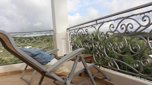 a rocking chair on a balcony with a view at Constantin in Dhémbla