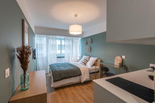 une petite chambre avec un lit et une cuisine dans l'établissement M110 Marquer Joli Studio proche du centre et de la gare, à Annemasse