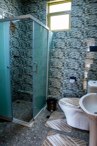 a bathroom with a shower and a toilet and a sink at Valley View KK 191 in Kigali
