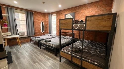 a room with three bunk beds and a brick wall at 31 Street Broadway Hotel in New York