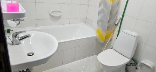 a white bathroom with a sink and a toilet at UrduEnglishFamilyApartmen in Sharjah