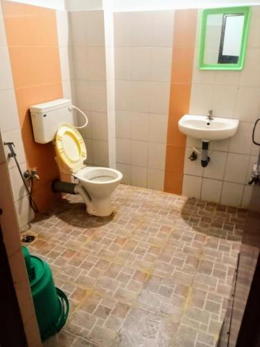 un baño con inodoro y lavabo en Sanman Regency next to Jaganmohan Palace, en Mysore