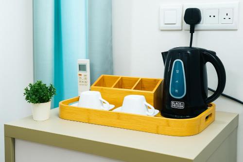 a tea kettle and cups on a counter at Cozy Vacation Home in Anuradhapura