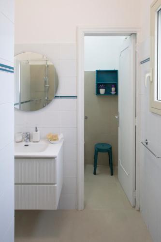 a white bathroom with a sink and a mirror at Domus Liventa B&B in Cursi