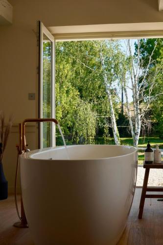 une baignoire assise devant une fenêtre dans l'établissement Maison L Gascony, à Lagardère