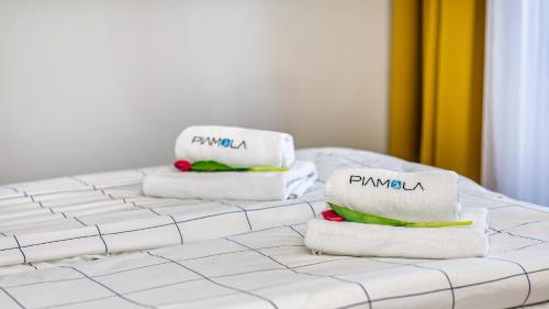 a stack of towels sitting on top of a bed at PERŁA MIERZEI Apartamenty Piamola in Sztutowo