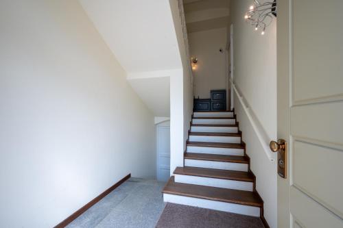 a staircase with white walls and wooden stairs at La tana dei sogni in Chieri