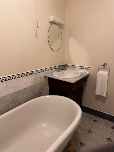 a bathroom with a tub and a sink at The Old Manor House Hotel in Keynsham