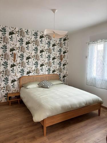 Ce lit se trouve dans une chambre dotée d'un mur. dans l'établissement La p'tite maison, à Forcalquier