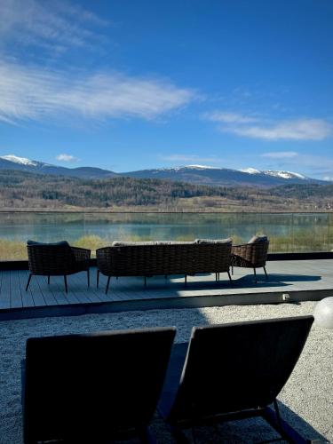 a group of benches sitting in front of a lake at Lake Hill Karkonosze Resort & Spa in Sosnówka