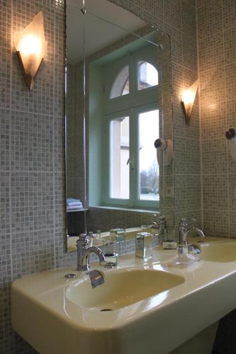 a bathroom with a sink and a mirror at Le Castel Guesthouse in Bayeux