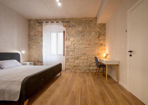 a bedroom with a bed and a table and a desk at Modern Design Old Town Apartment by MN Property in Kotor