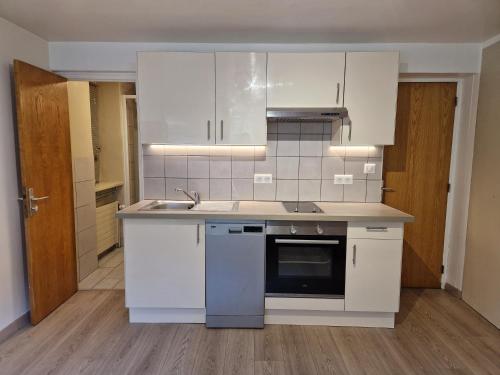 une cuisine avec des armoires blanches et un évier dans l'établissement Superb studio très bien situé à Courchevel 1300, à Courchevel