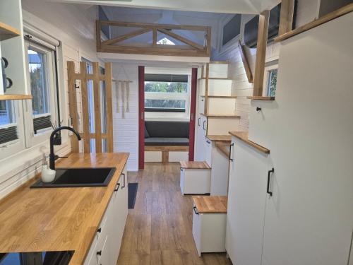 a kitchen in a tiny house with a sink at Tajnikowo Sekretny Tiny House Anyżek in Łubiana