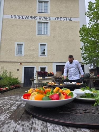 a man preparing food on a table with plates of food at Norrqvarn Hotel & Resort by Vänerport in Lyrestad