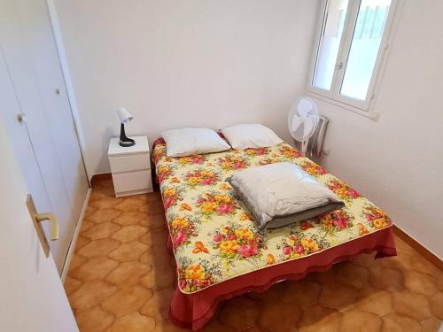 - une petite chambre dotée d'un lit avec un couvre-lit floral dans l'établissement T2 avec Parking Sécurisé, à 300 m de la Plage, Climatisation Mobile - FR-1-316-343, à Six-Fours-les-Plages