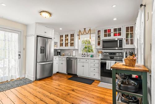 a kitchen with white cabinets and stainless steel appliances at Historic Seaside Captains House Downtown Mystic in Groton