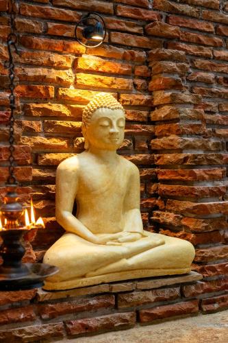 a statue sitting on a wall next to a brick wall at Cozy Vacation Home in Anuradhapura