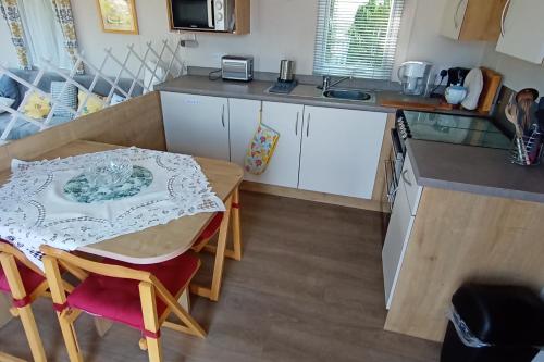 a kitchen with a table and a small table and a kitchen gmaxwell gmaxwell gmaxwell gmaxwell at Sleeps 6 Pets Allowed & Free Parking in Weymouth