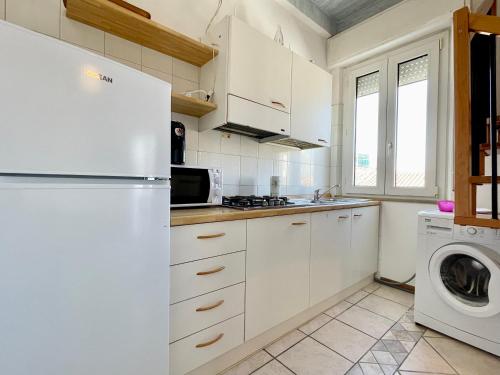 a kitchen with a refrigerator and a washer and dryer at Bilocale vicinissimo mare - La casa del Bagnino in Cattolica