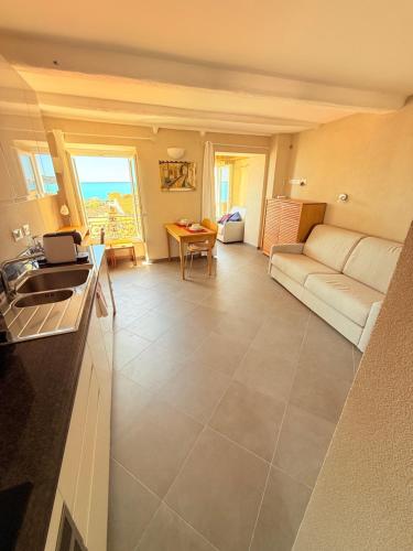 un salon avec un canapé et une table dans l'établissement Charmant Studio Perché sur Mer - Vieux Menton, à Menton