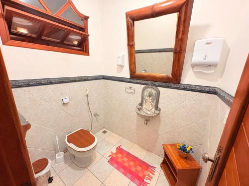 a bathroom with a toilet and a mirror at Terra do Sol Pousada e Hostel in Porto Seguro