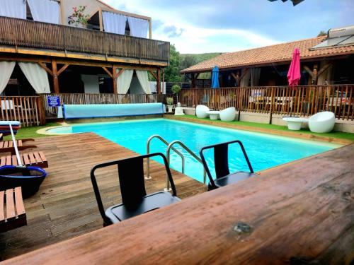 a swimming pool with a table and a wooden deck at GITES O FIL DE L'EAU piscine spa accès rivière in Omessa
