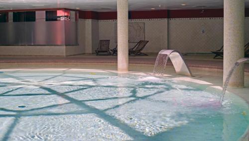a swimming pool with a water fountain in a building at Holiday Premium Resort in Benalmádena