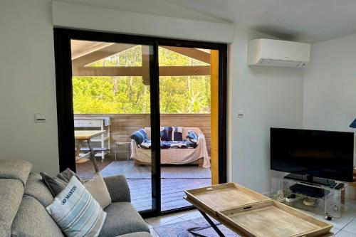 un salon avec un canapé et une porte coulissante en verre dans l'établissement Appartement Kôte Mer, à Seignosse