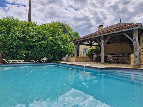 - une piscine avec un kiosque et de l'eau bleue dans l'établissement La Maison du Lac, à Estipouy