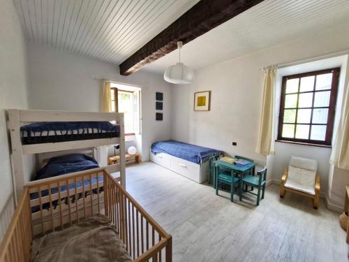 une chambre avec deux lits superposés et une table dans l'établissement La Maison du Lac, à Estipouy