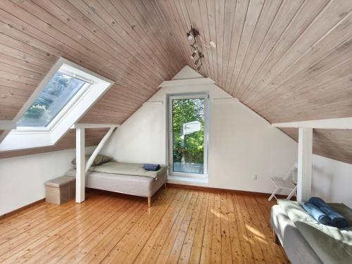 a attic room with a bed and a window at Riverview Cottage in Randbøl